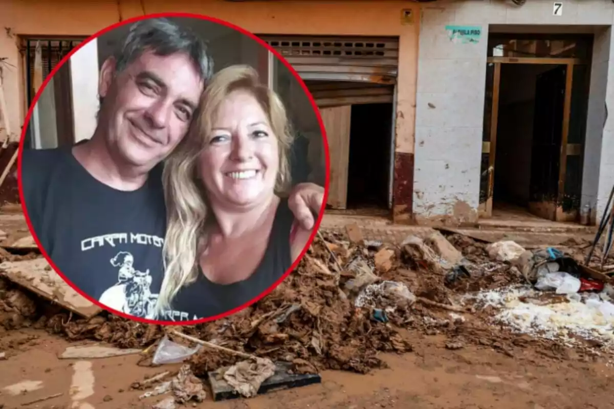 Una pareja sonriente aparece en un recuadro sobre una imagen de fondo que muestra una calle con escombros y barro frente a un edificio.