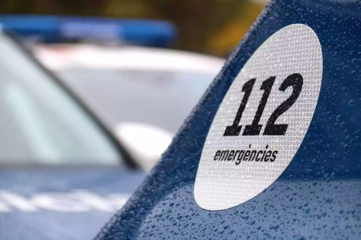 Logo del 112 en un coche de los Mossos de Esquadra con gotas de lluvia