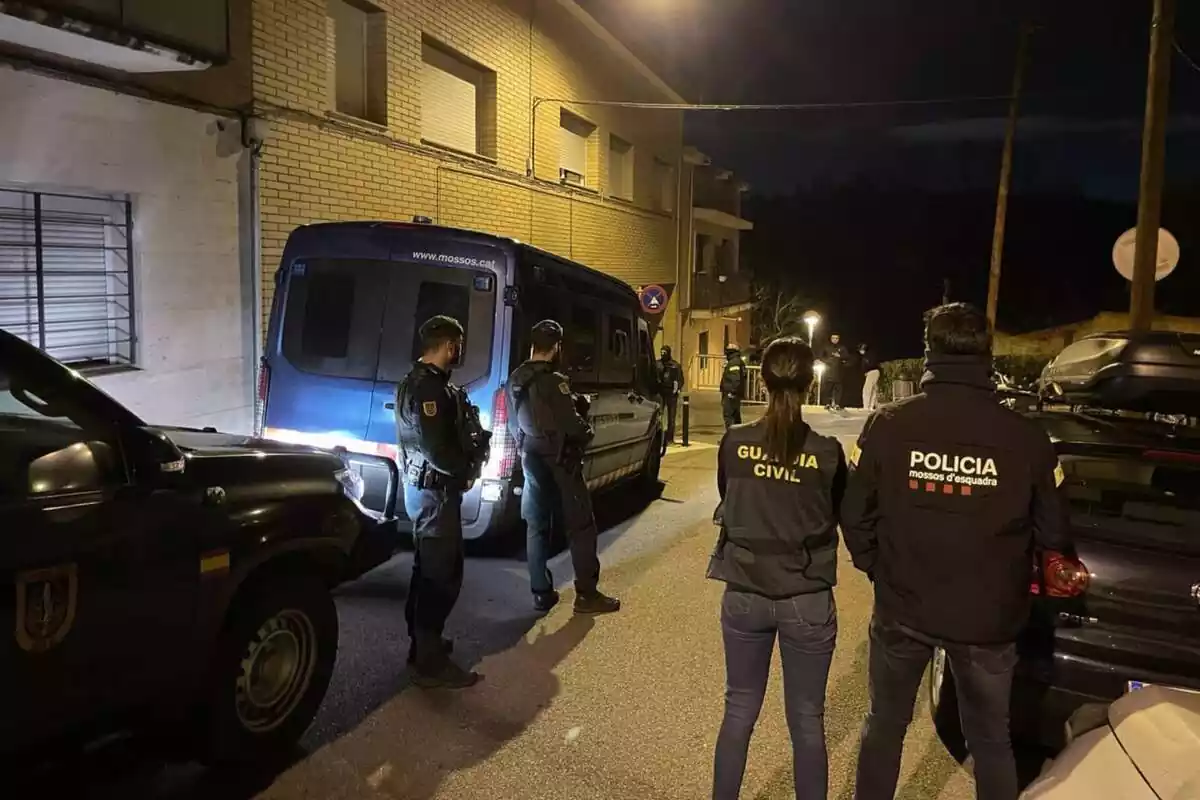 Varios agentes de los Mossos d'Esquadra, de espaldas, en la operación antiterrorista que ha tenido lugar en Cataluña hoy, 16 de enero de 2024