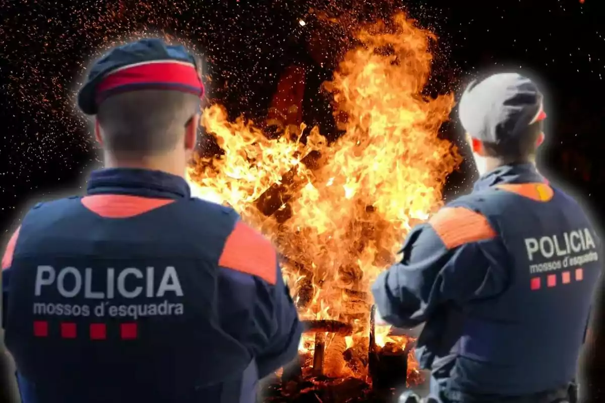 Dos agentes de la policía de los Mossos d'Esquadra observan un gran incendio.