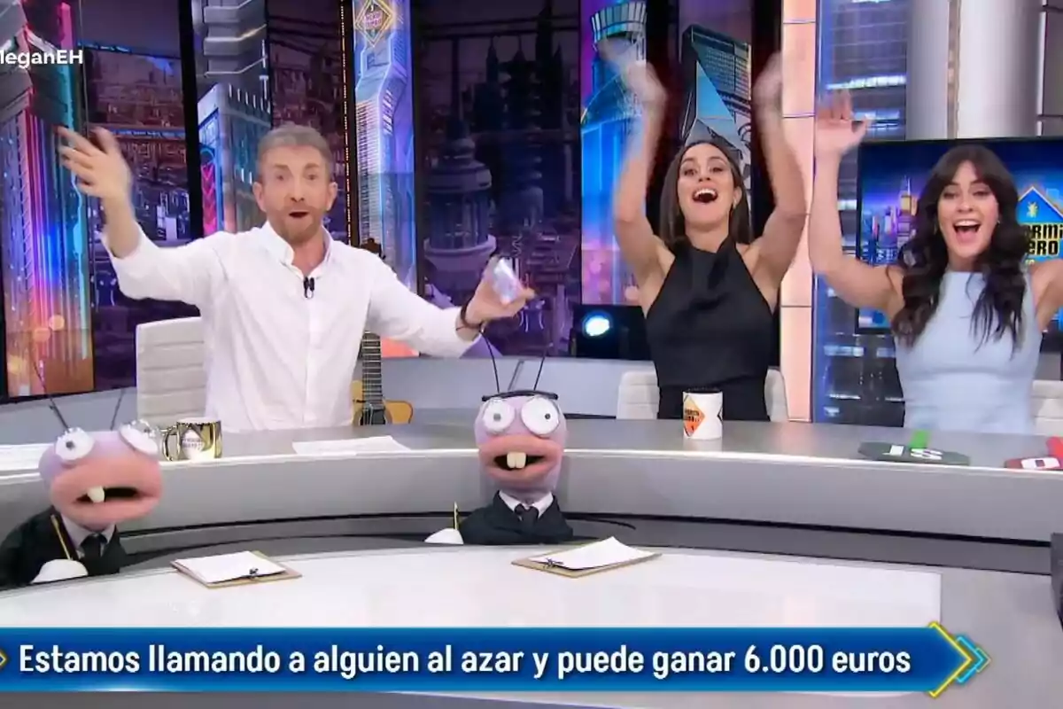 Pablo Motos, Eva Ugarte y Megan Montaner en 'El Hormiguero' celebrando con entusiasmo mientras dos hormigas están en la mesa frente a ellos. Pablo Motos, Eva Ugarte y Megan Montaner en 'El Hormiguero' celebrando con entusiasmo mientras dos hormigas están en la mesa frente a ellos.