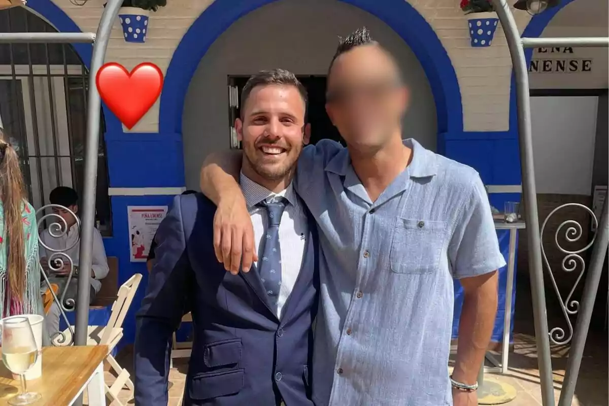 Dos personas posan juntas sonriendo en un entorno al aire libre con decoración azul y blanca y un emoji de corazón rojo en la esquina superior izquierda. Dos personas posan juntas sonriendo en un entorno al aire libre con decoración azul y blanca y un emoji de corazón rojo en la esquina superior izquierda.
