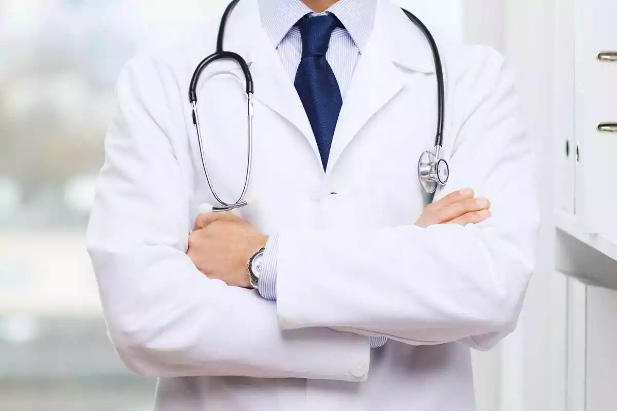 Un médico con bata blanca y con los brazos cruzados