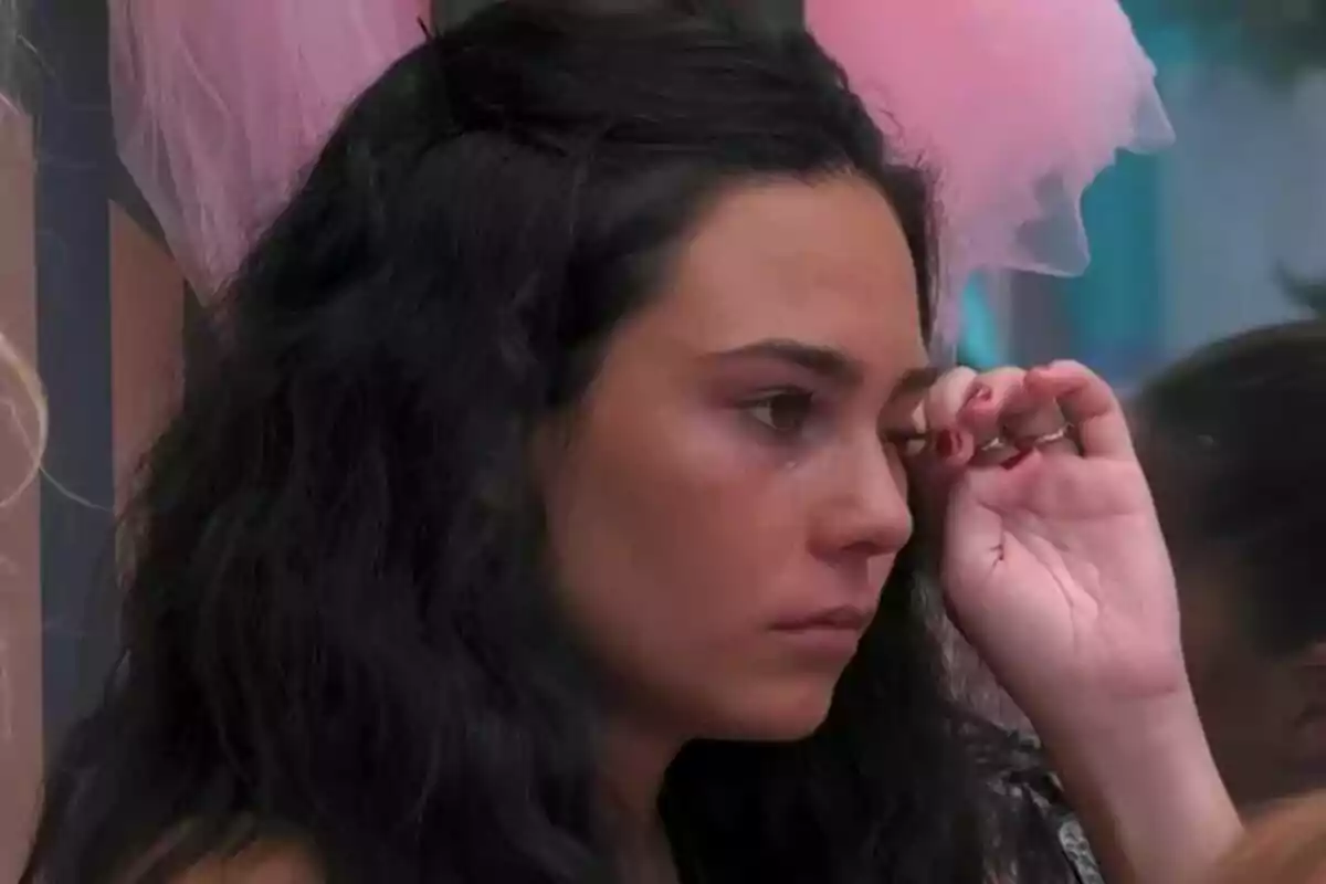 Nerea con cabello oscuro limpiándose una lágrima en el rostro en la casa de 'Gran Hermano'.