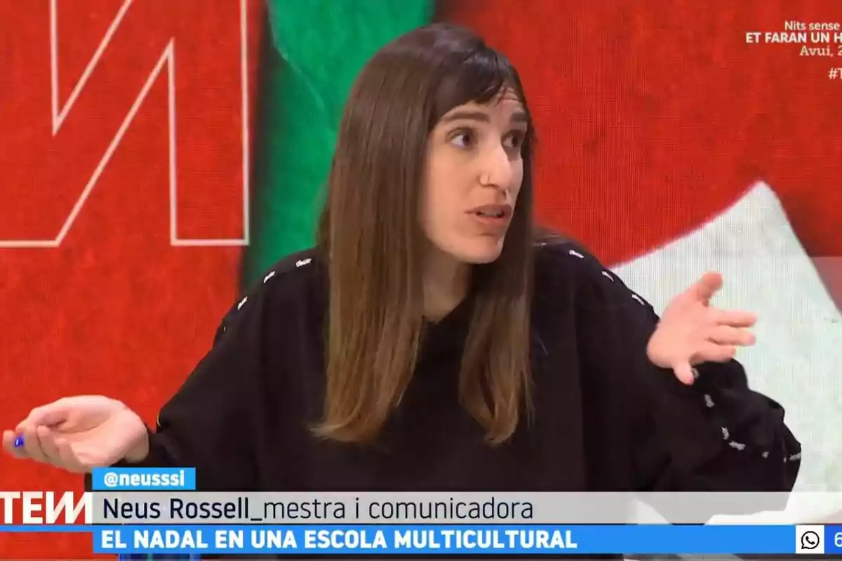 Una mujer con cabello largo y oscuro está hablando en un programa de televisión, con un fondo colorido detrás de ella y un texto en la parte inferior de la pantalla.