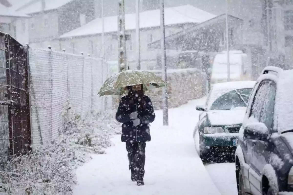 Imagen de una persona caminando por una calle de Pedrafita do Cebreiro, a 5 de enero de 2024, durante una nevada