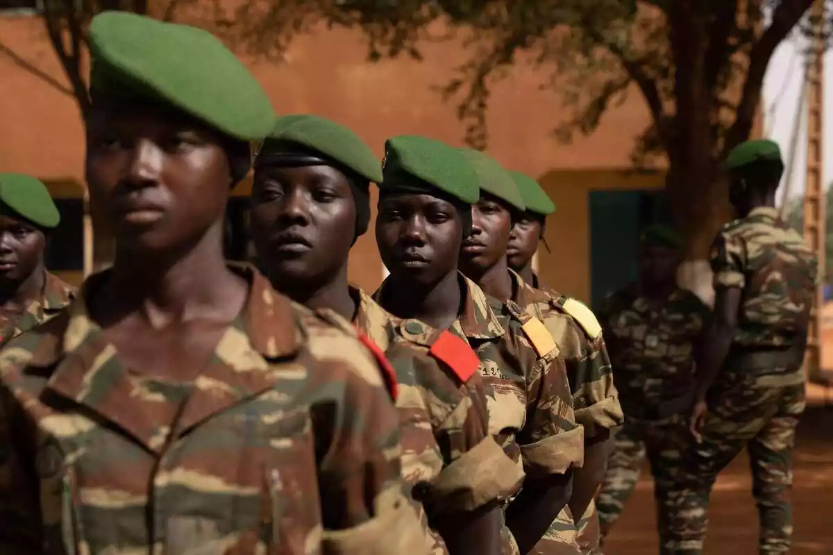 Plano medio de varias militares de Níger en fila india con uniforme militar