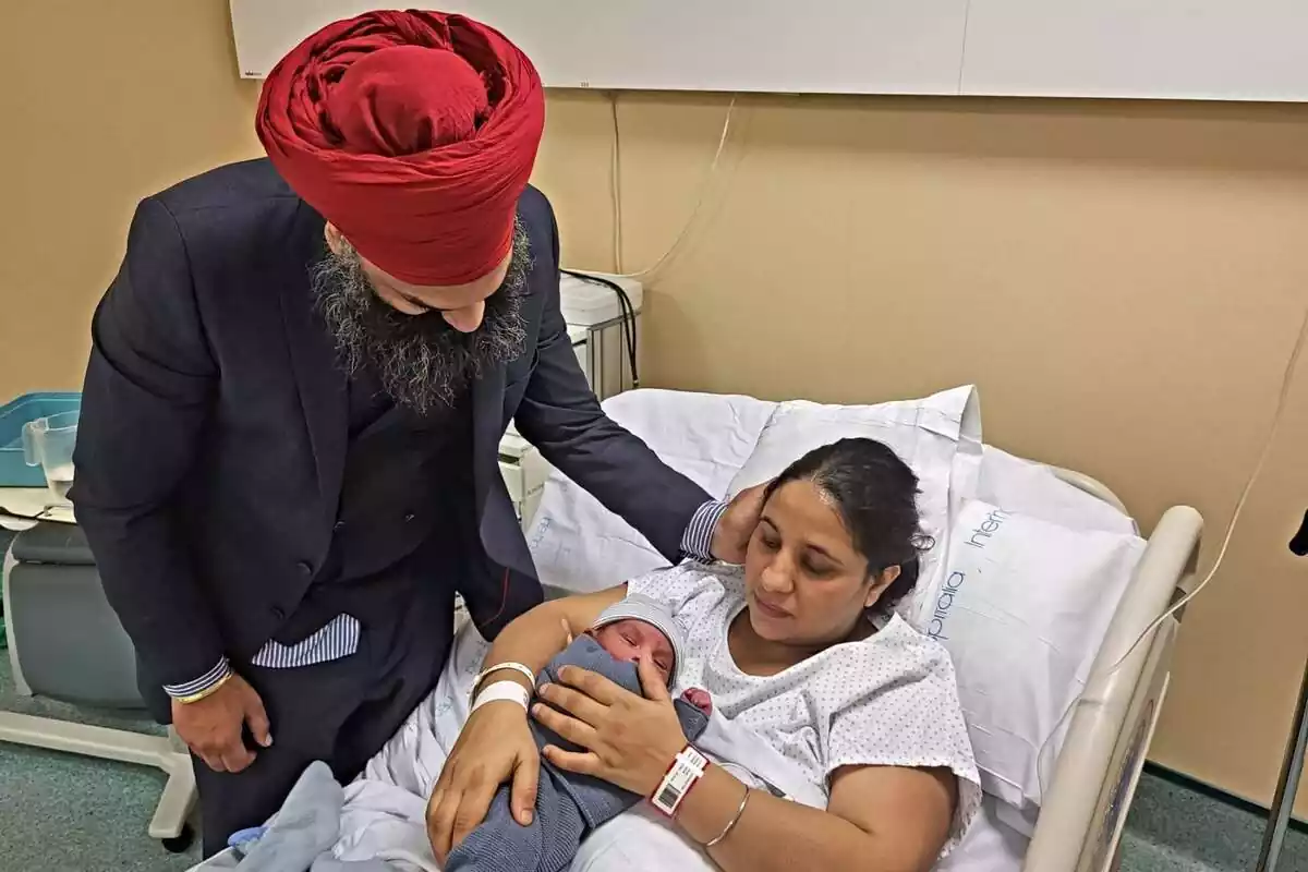 Rupindar Kaur i Amrik Singh en una habitación del hospital de Figueres con su niño recién nacido en brazos de la madre