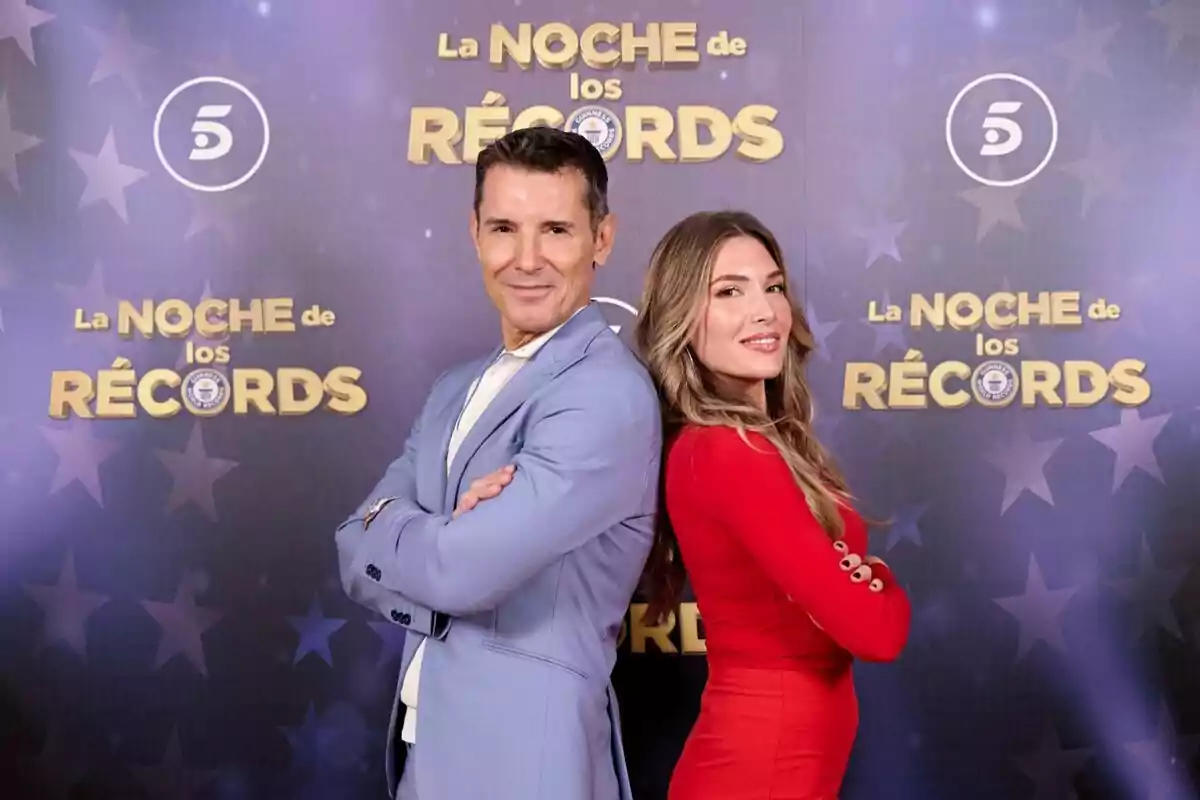 Jesús Vázquez y Álex Blanquer posan de espaldas en un evento llamado "La Noche de los Récords" con un fondo decorado con estrellas y logotipos.