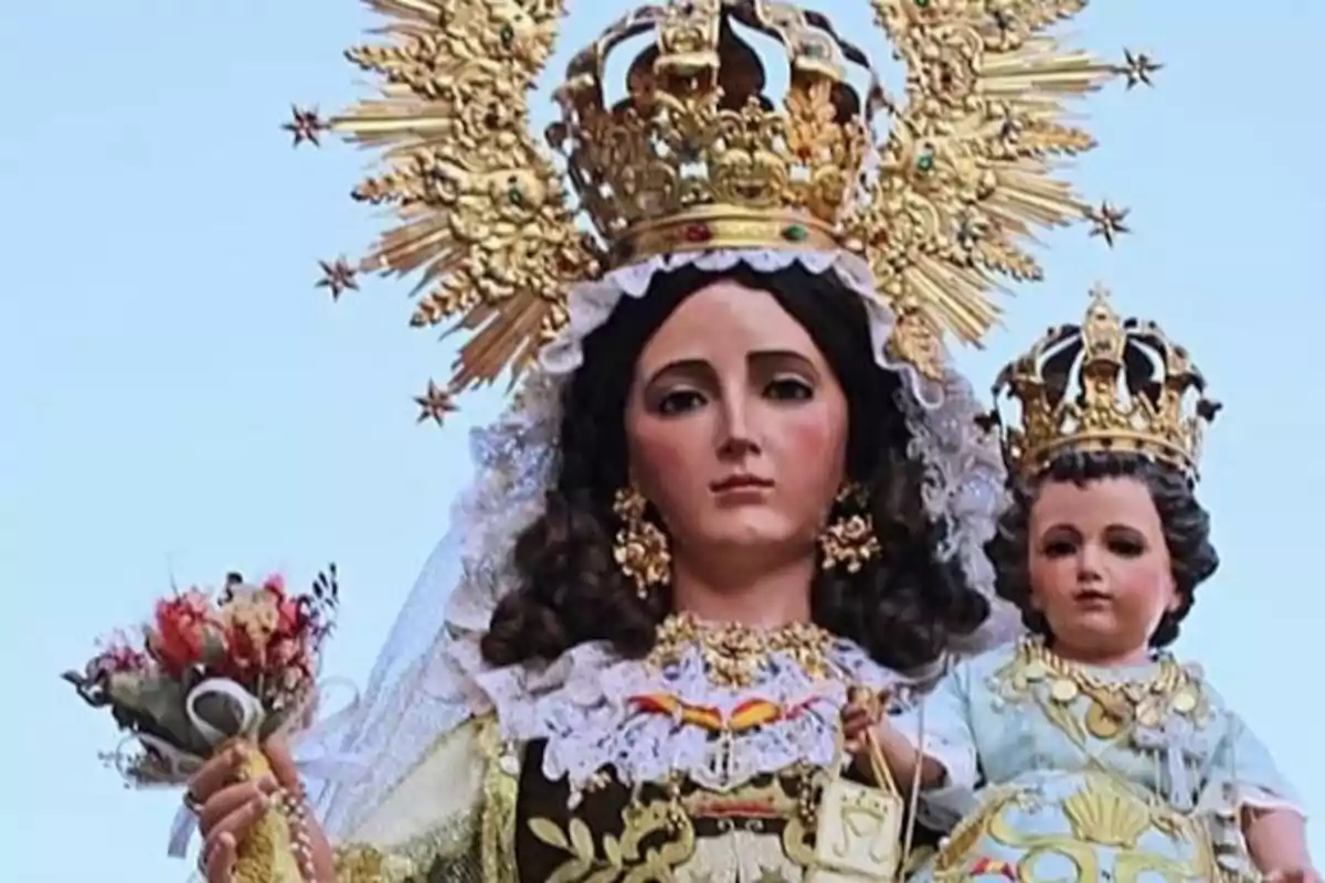 Imagen de una estatua religiosa de una mujer con corona dorada y un niño también con corona dorada.