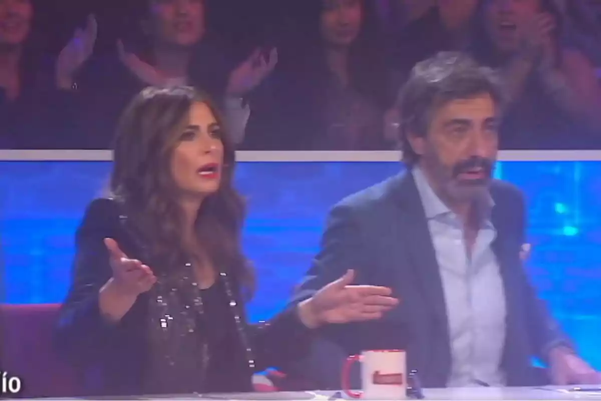 Nuria Roca y Juan del Val en El Desafío muestran expresiones de sorpresa y confusión mientras el público aplaude en el fondo Nuria Roca y Juan del Val en El Desafío muestran expresiones de sorpresa y confusión mientras el público aplaude en el fondo
