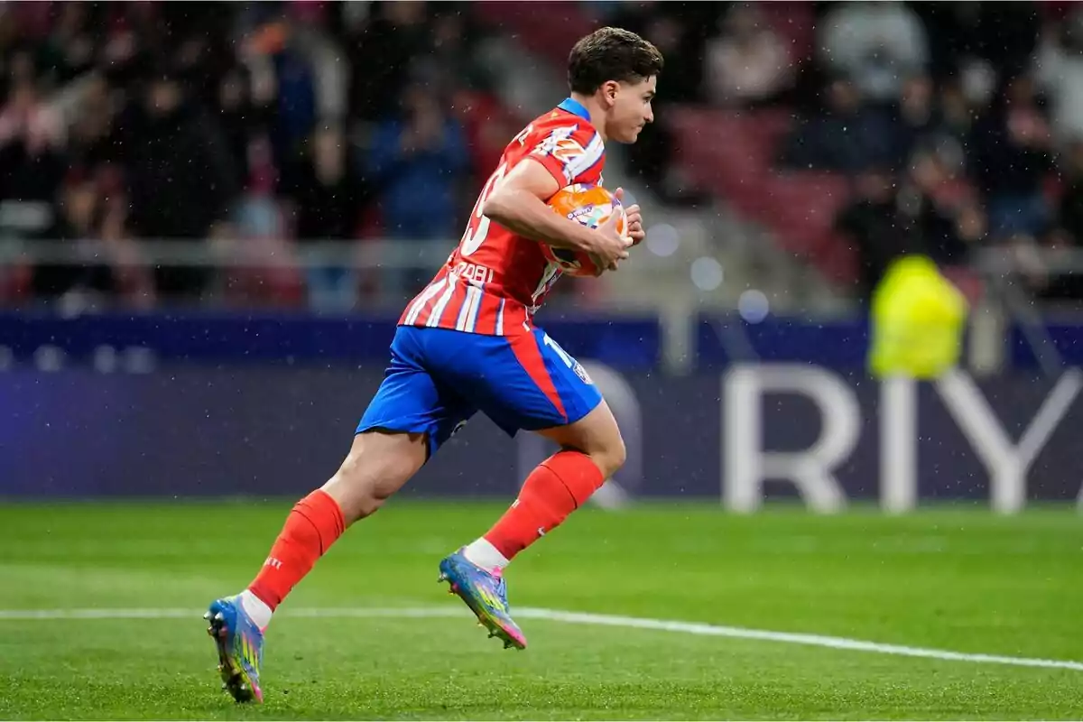 Jugador de fútbol corriendo en el campo con el balón en las manos durante un partido. Jugador de fútbol corriendo en el campo con el balón en las manos durante un partido.