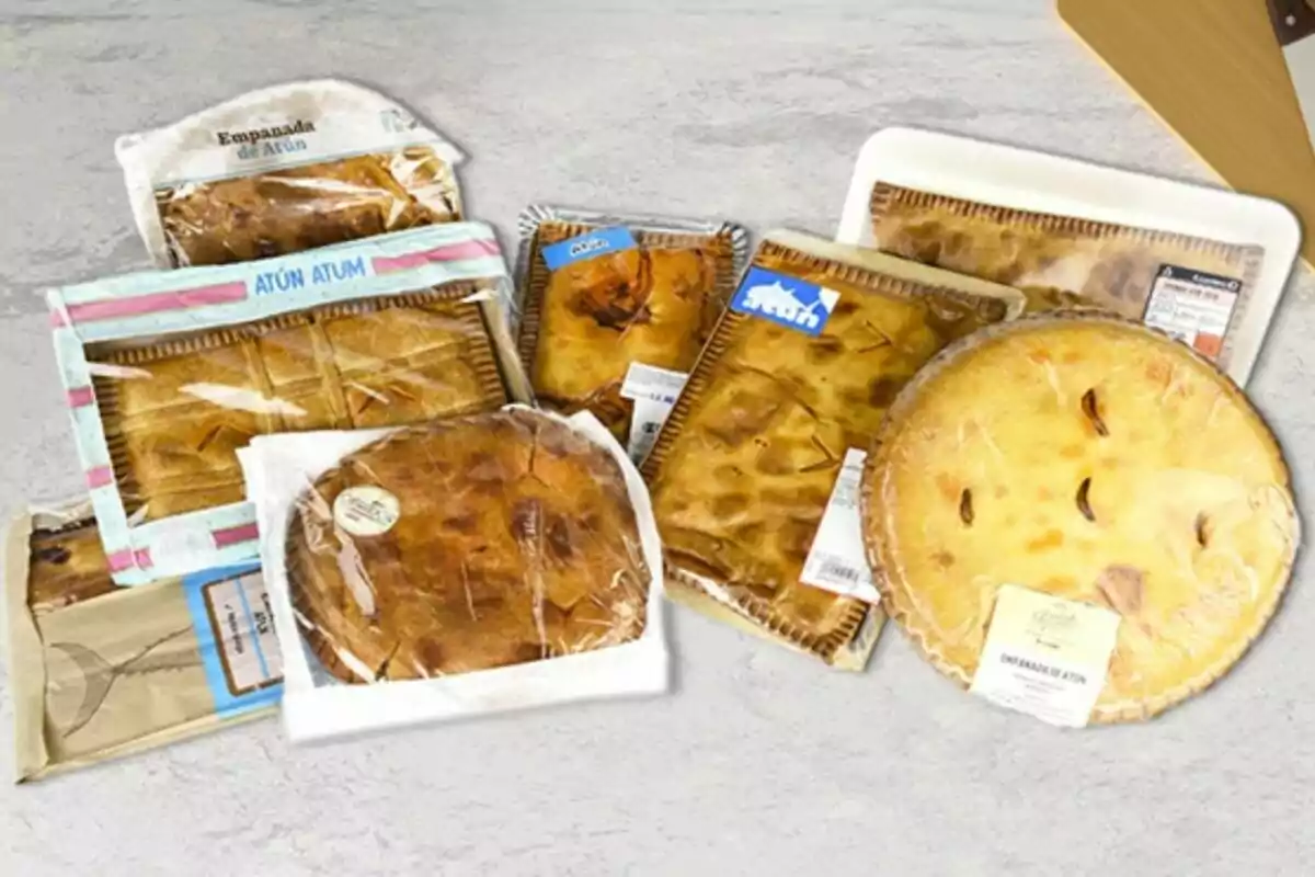 Una variedad de empanadas de atún en diferentes empaques sobre una superficie gris. Una variedad de empanadas de atún en diferentes empaques sobre una superficie gris.