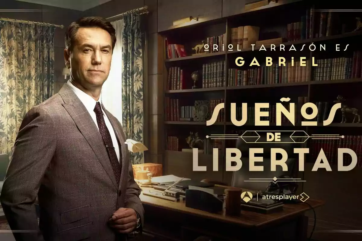 Oriol Tarrasón de traje está de pie en una oficina elegante con estanterías llenas de libros y un escritorio, junto al texto Oriol Tarrasón de traje está de pie en una oficina elegante con estanterías llenas de libros y un escritorio, junto al texto