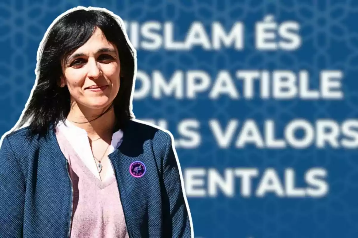 Una mujer con cabello oscuro y una chaqueta azul está de pie frente a un fondo azul con texto en blanco que dice "ISLAM ÉS COMPATIBLE ELS VALORS MENTALS".