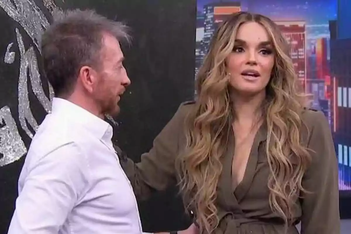 Pablo Motos y Melody conversan en un set de El Hormiguero con fondo de ciudad iluminada