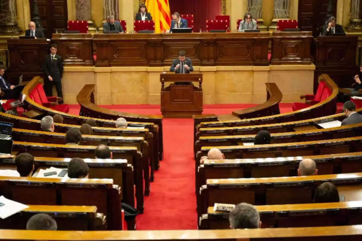 Plano general desde la grada de detrás del hemiciclo del Parlament de Catalunya con Pere Aragonès hablando desde el atril