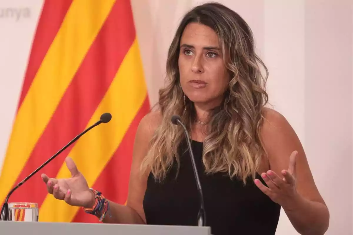 Plano medio de Patrícia Plaja con una camiseta sin mangas negra y abriendo los brazos en la sala de prensa del Palau de la Generalitat