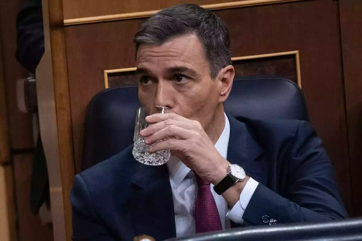 Primer plano de Pedro Sánchez en su escaño del Congreso bebiendo un vaso de agua