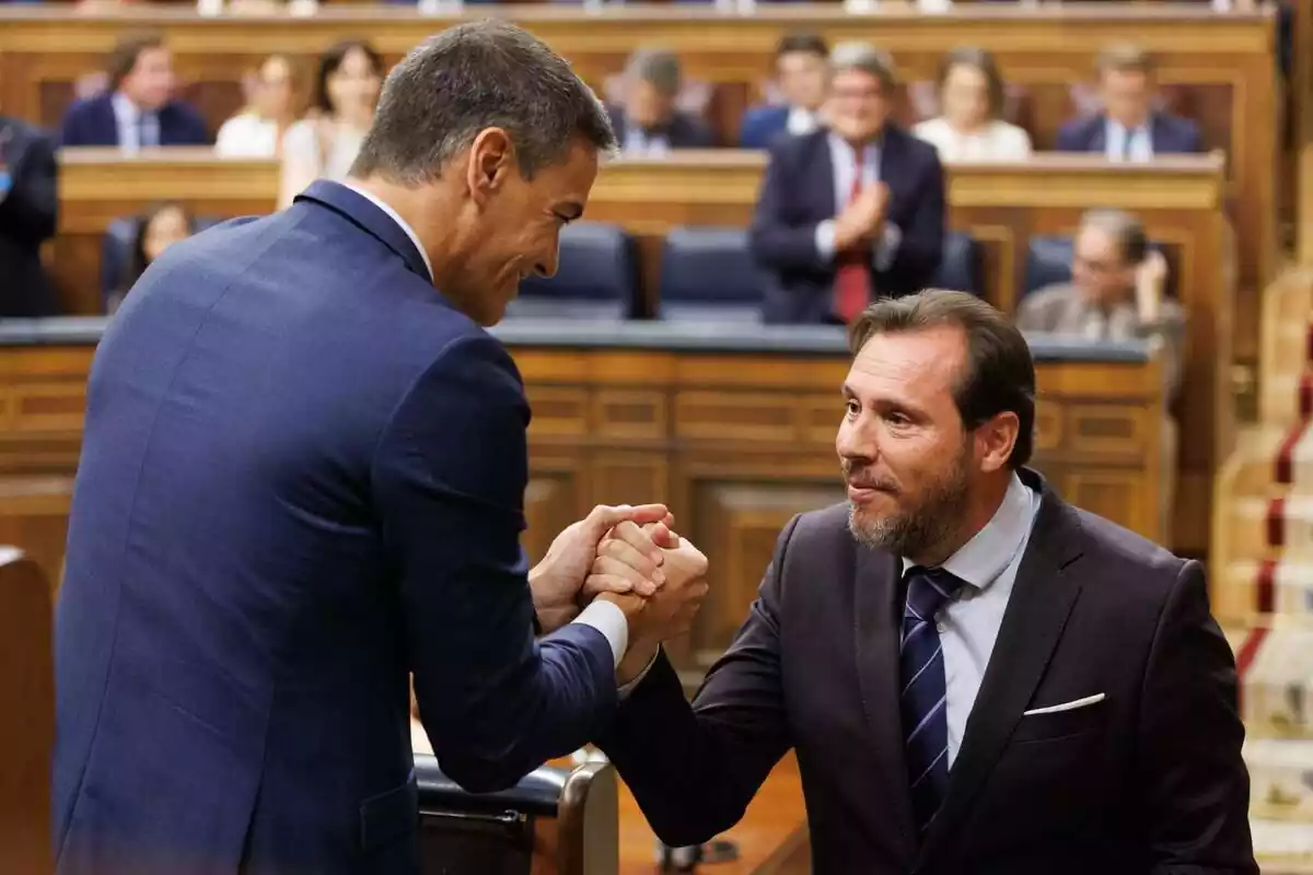 Pedro Sánchez y Óscar Puente dándose la mano amistosamente en el hemiciclo del Congreso de los Diputados