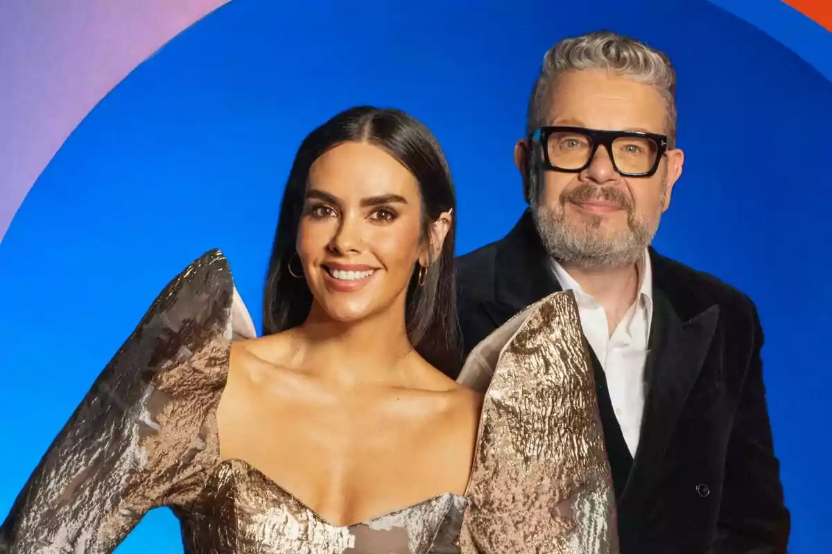 Cristina Pedroche y Alberto Chicote posando juntas en un fondo azul con un arco iris estilizado.