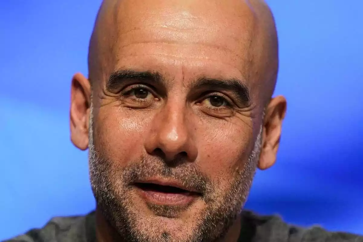 Primer plano de Pep Guardiola sonriendo y mirando a cámara