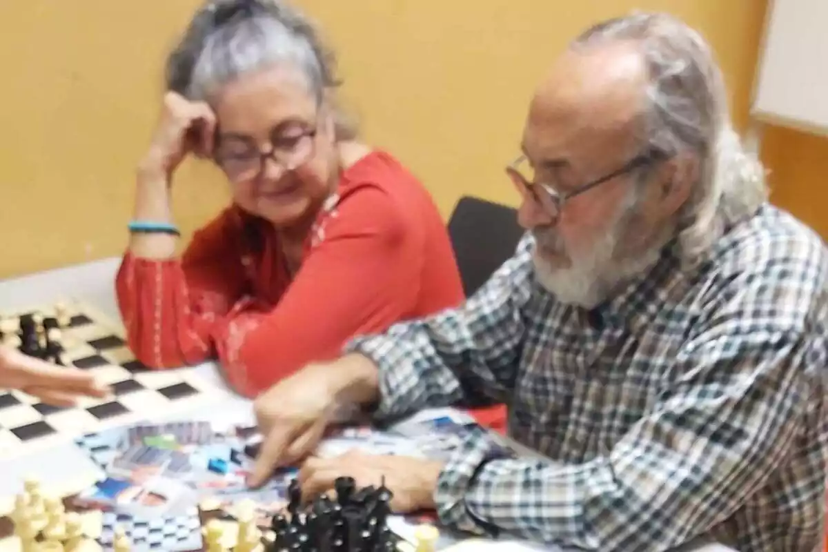 Pep Melendres jugando al ajedrez al lado de una mujer Pep Melendres jugando al ajedrez al lado de una mujer