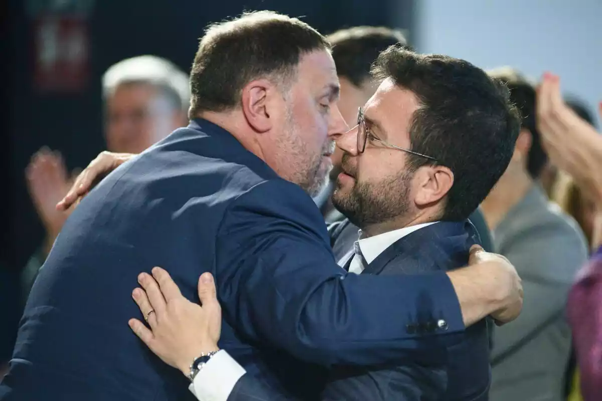 Pere Aragonès y Oriol Junqueras dándose un abrazo en un acto de campaña para las Elecciones de Cataluña 2024