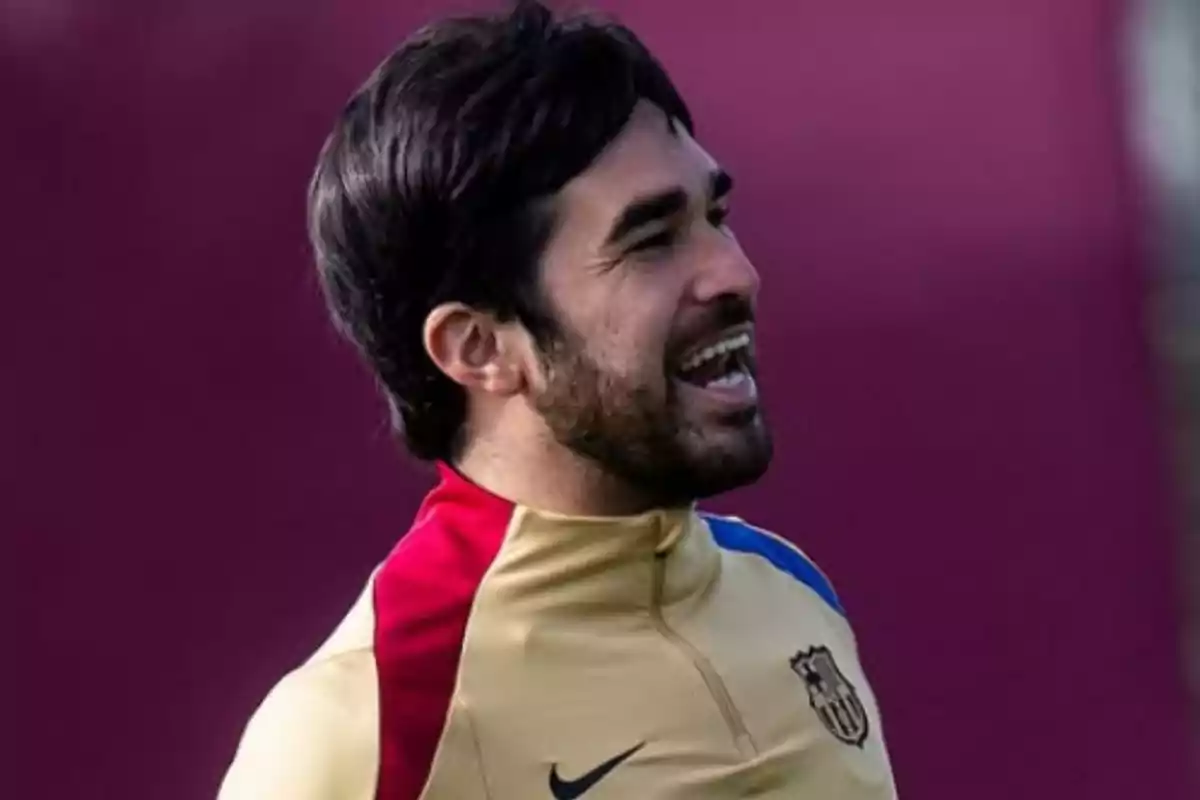 Un hombre con uniforme deportivo sonríe mientras está al aire libre. Un hombre con uniforme deportivo sonríe mientras está al aire libre.