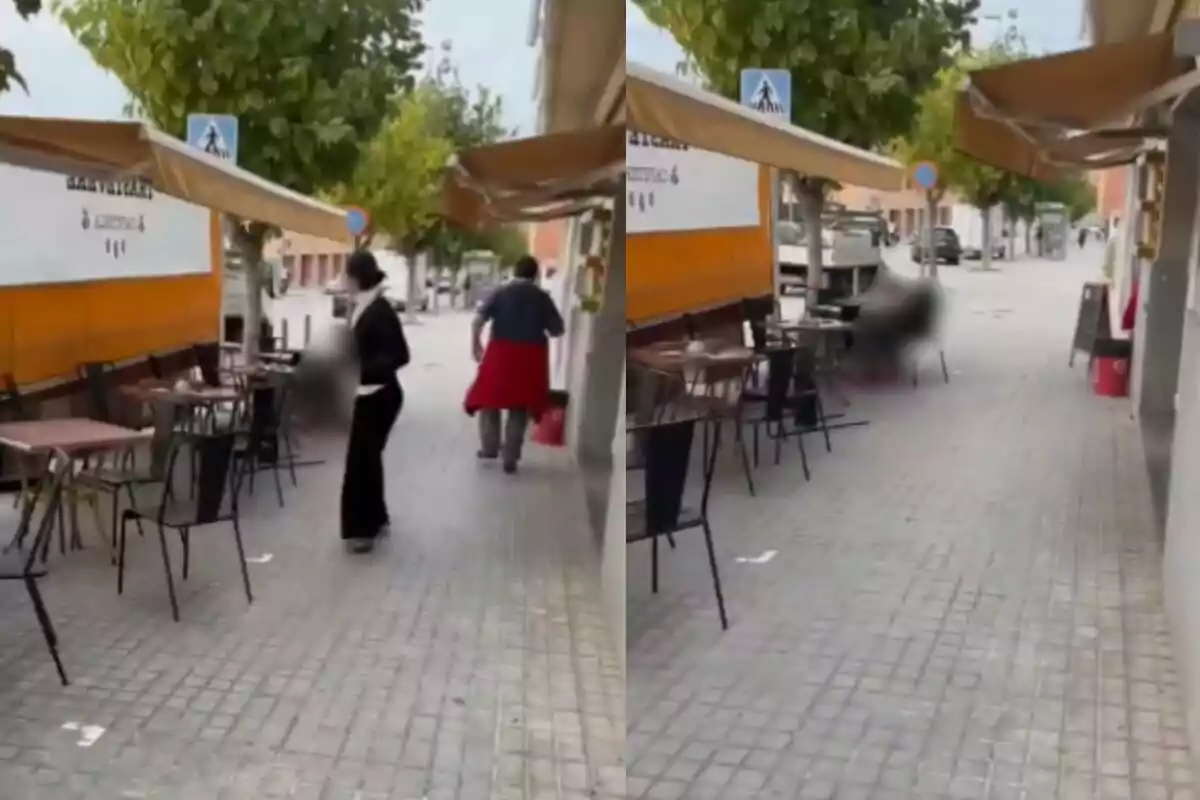 Una calle con mesas y sillas al aire libre junto a un restaurante con personas caminando.