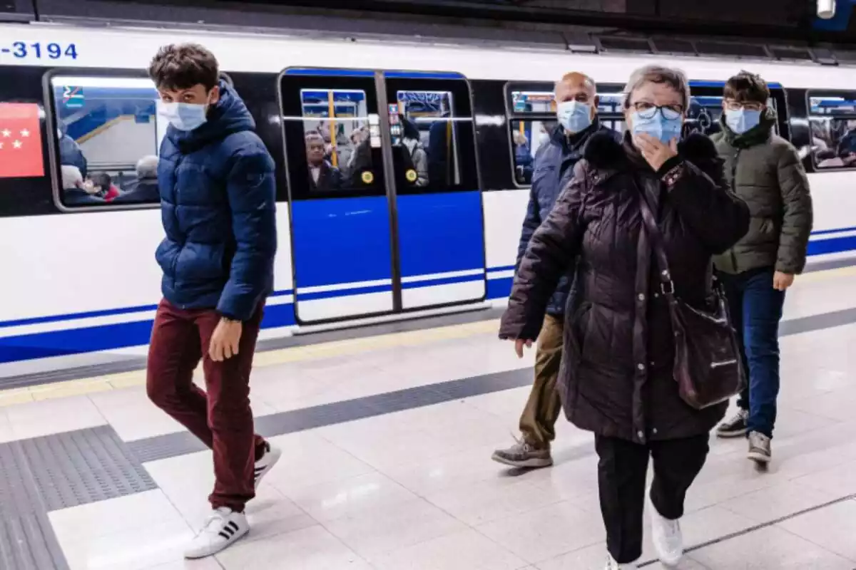 Varias personas con mascarilla en un andén del Metro de Madrid