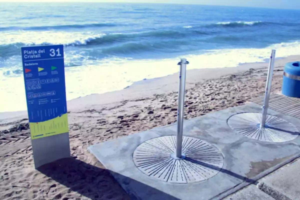 Playa con duchas y un cartel informativo junto al mar. Playa con duchas y un cartel informativo junto al mar.