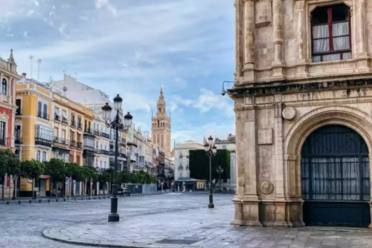 Calle con edificios históricos y una torre al fondo en un día despejado. Calle con edificios históricos y una torre al fondo en un día despejado.