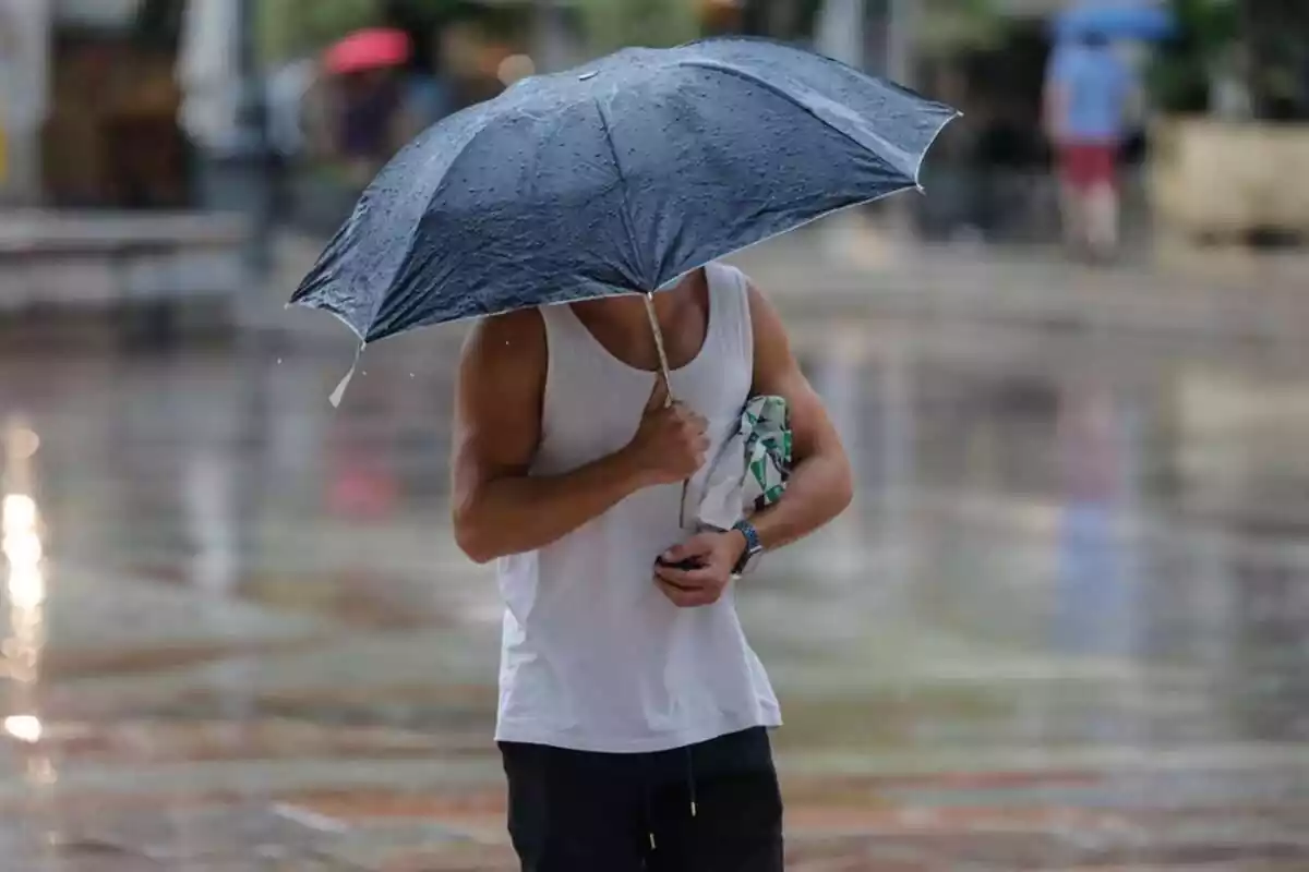 Imagen de un hombre escapándose de la lluvia