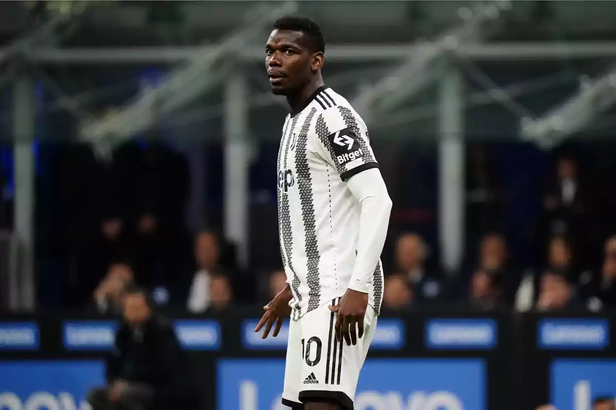 Un jugador de fútbol con uniforme blanco y negro en el campo durante un partido. Un jugador de fútbol con uniforme blanco y negro en el campo durante un partido.