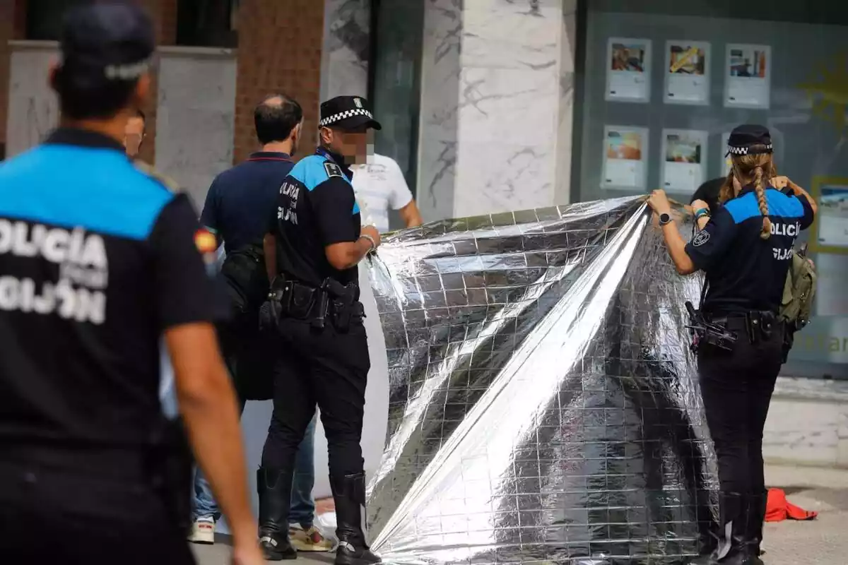 Policia Local de Gijón, tapando el cadáver de un hombre asesinado