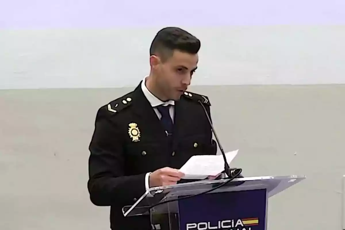 Un hombre con uniforme de policía habla en un podio con un micrófono.