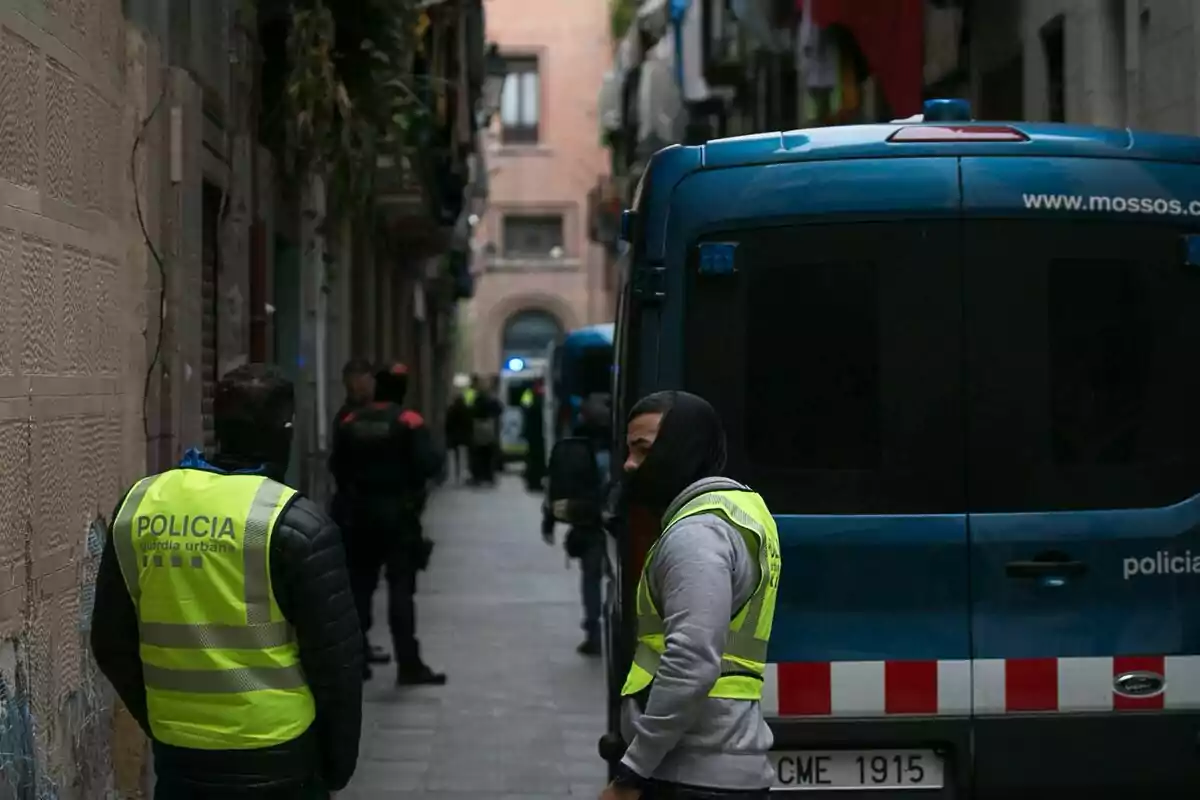 Agentes de Mossos d"Esquadra y Guardia Urbana con una mujer detenida tras los registros efectuados en los "narcopisos" en el "El Raval", en el distrito de Ciutat Vella de Barcelona.