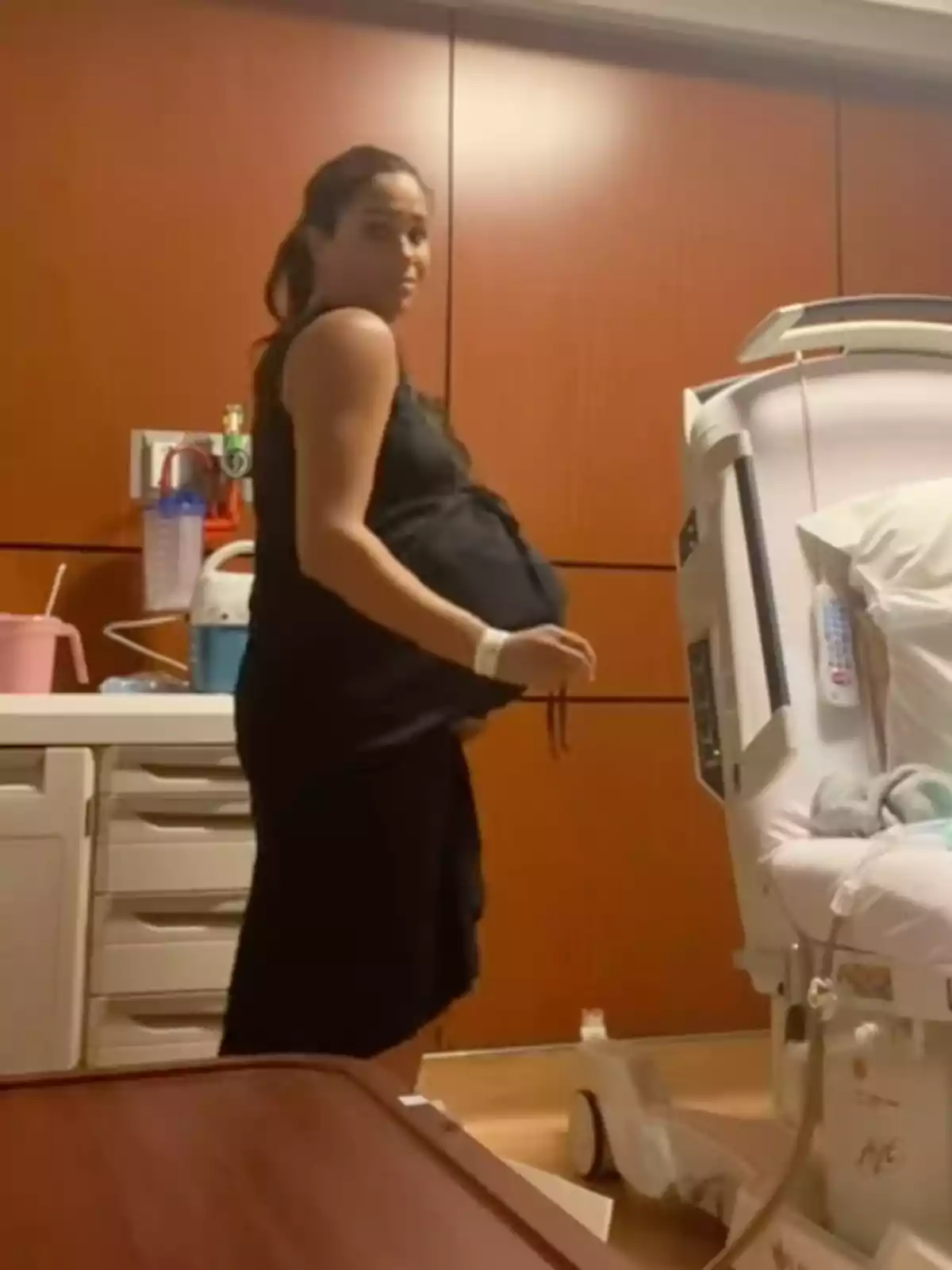 Meghan Markle embarazada de pie en una habitación de hospital junto a una cama médica Meghan Markle embarazada de pie en una habitación de hospital junto a una cama médica