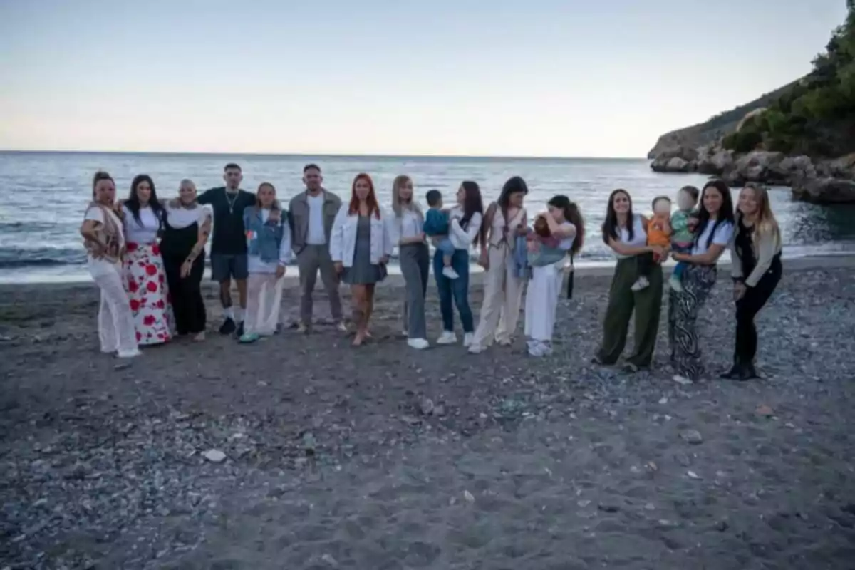 Un grupo de personas posando en la playa al atardecer con el mar de fondo. Un grupo de personas posando en la playa al atardecer con el mar de fondo.