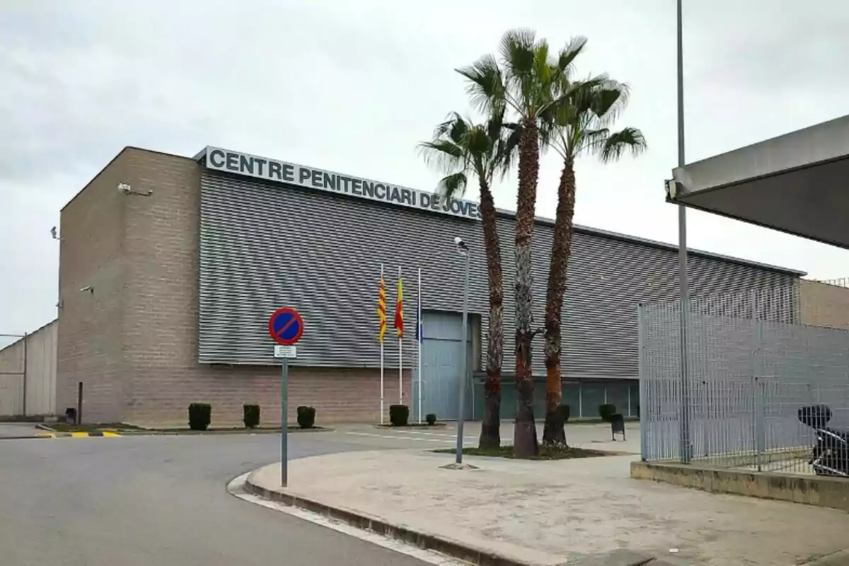 Edificio del Centre Penitenciari de Joves con palmeras y banderas en la entrada.