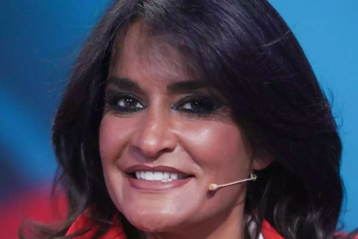 Primer plano de Aida Nízar sonriendo con un micrófono en la cara