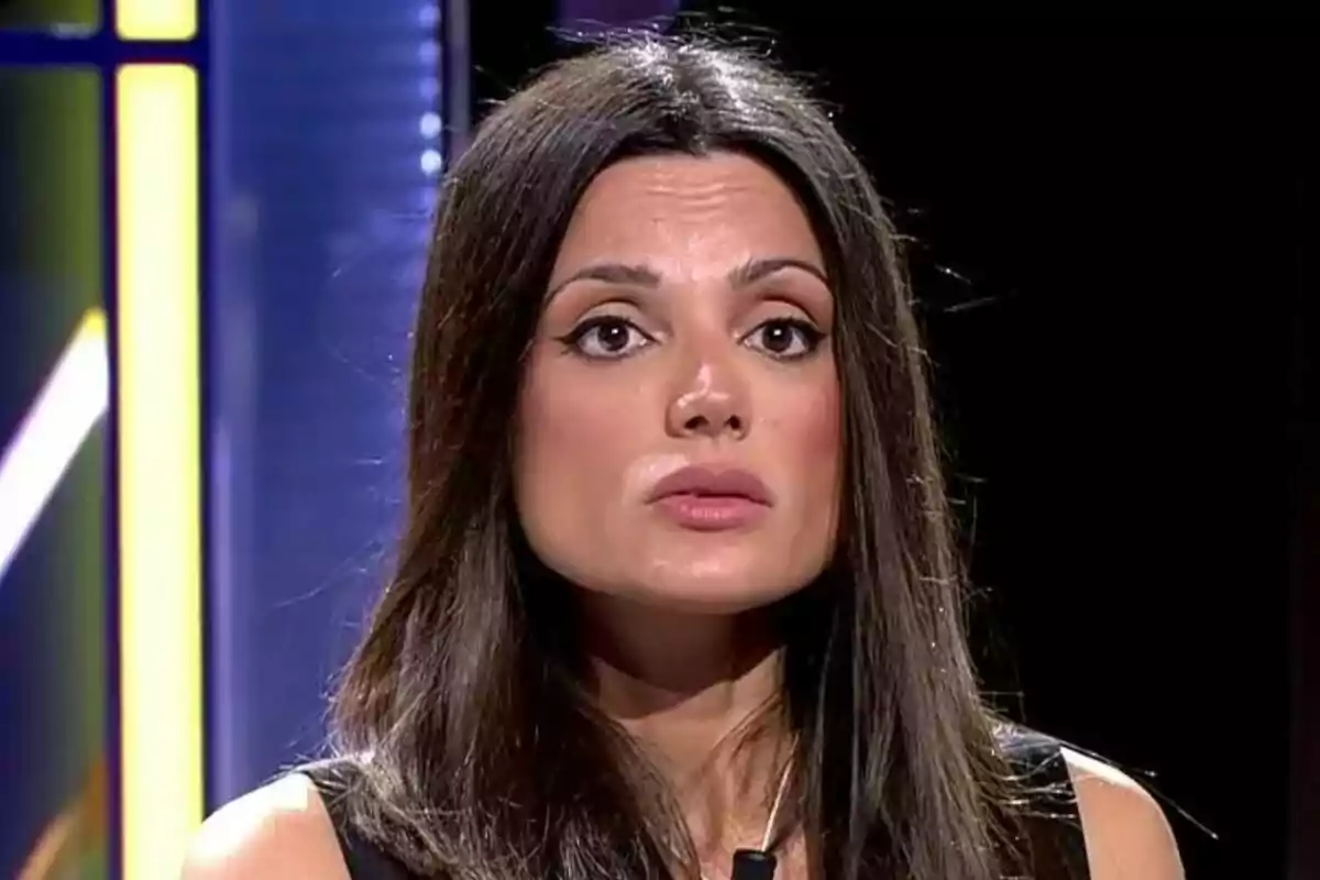 Alba Muñoz de cabello oscuro con expresión seria en un entorno iluminado. Alba Muñoz de cabello oscuro con expresión seria en un entorno iluminado.