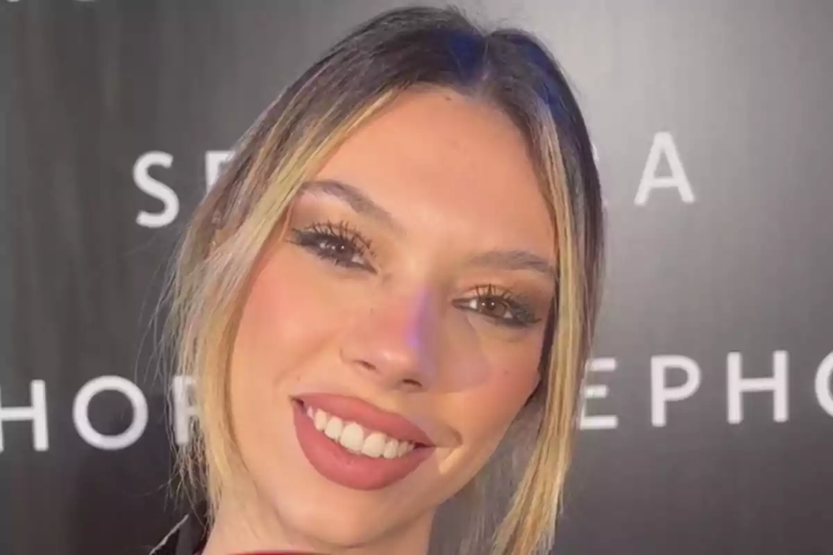 Alejandra Rubio sonriendo frente a un fondo con letras blancas.