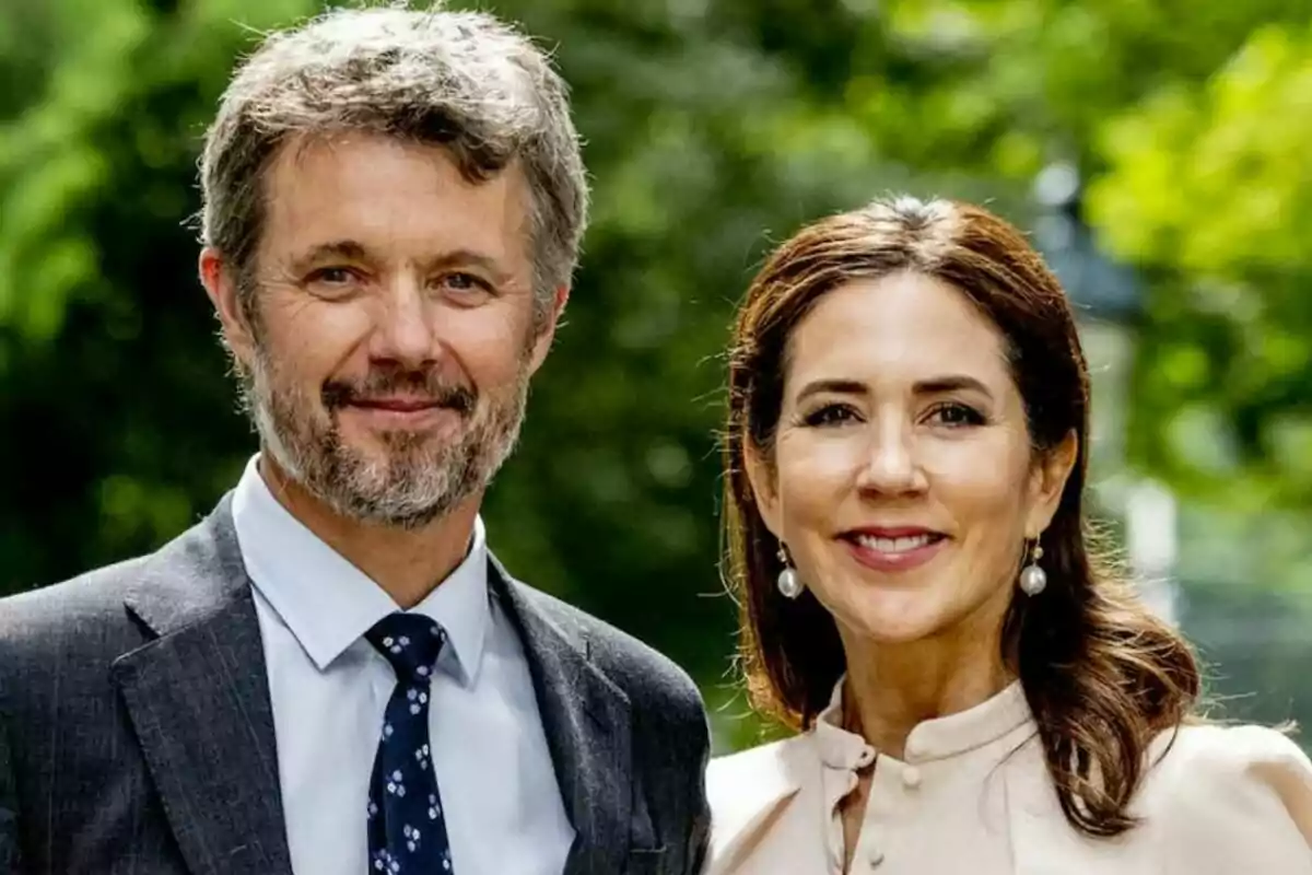 Federico de Dinamarca y Mary Donaldson sonriente posando al aire libre con un fondo de vegetación.