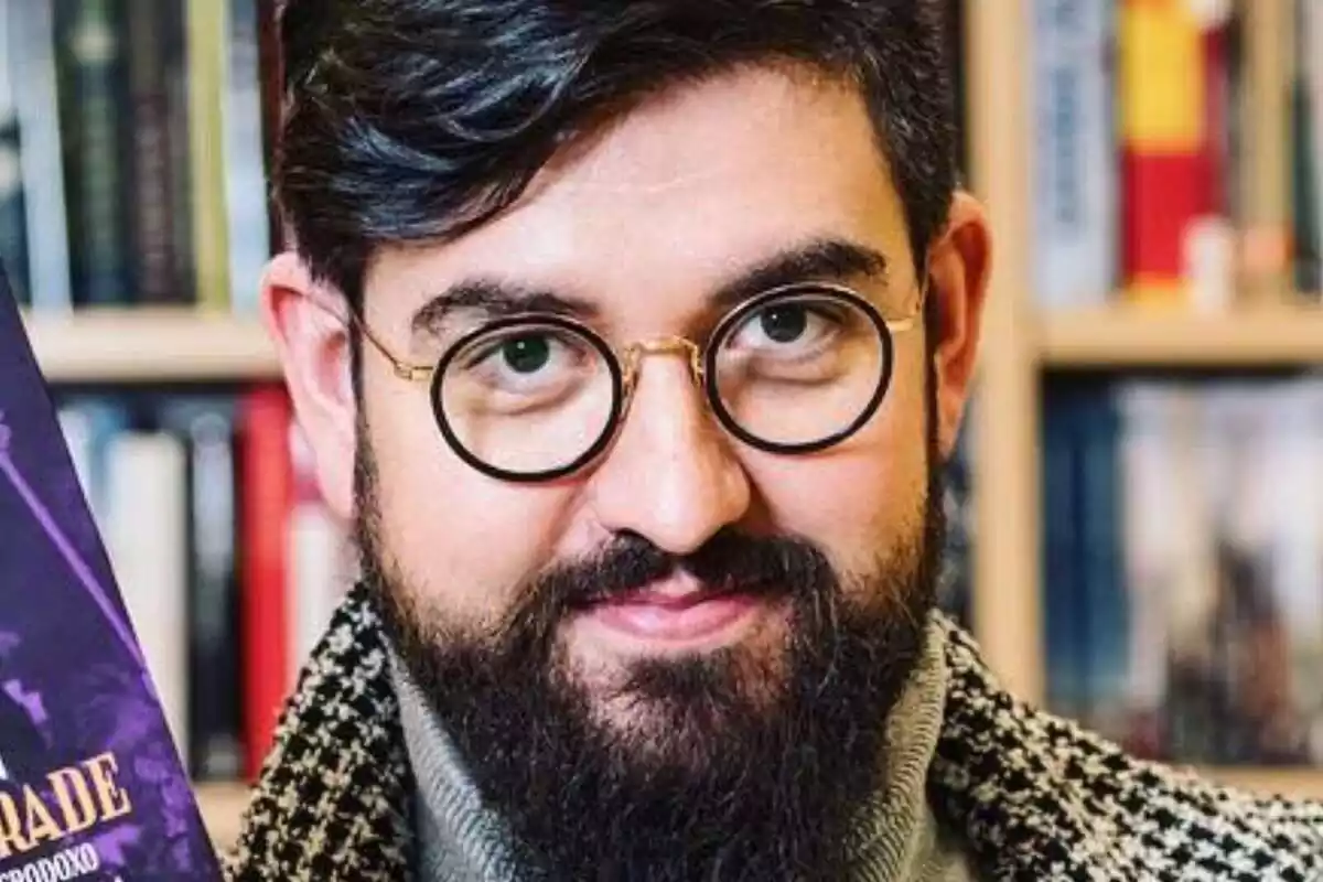 Primer plano del humorista Manu Sánchez mirando a cámara con una estanteria llena de libros a sus espaldas Primer plano del humorista Manu Sánchez mirando a cámara con una estanteria llena de libros a sus espaldas