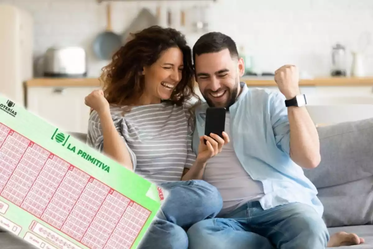 Una pareja sonriente celebra con un boleto de lotería "La Primitiva" en la mano.