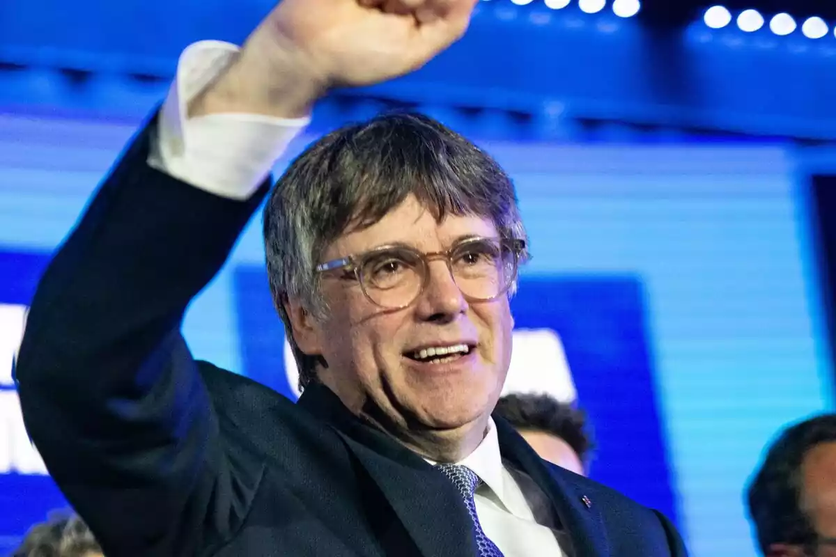 Plano medio de Carles Puigdemont sonriendo y levantando el puño en señal de victoria