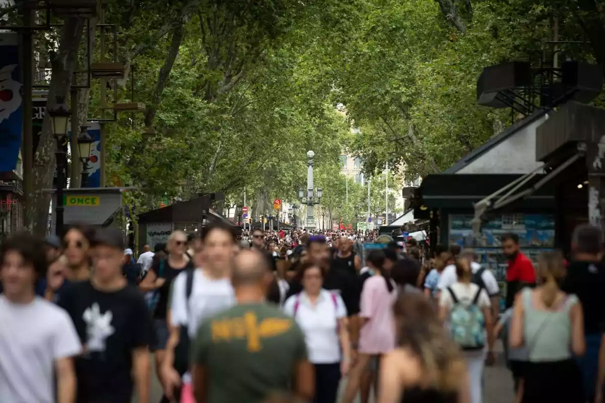 Imagen de decenas de personas andando por la rambla de barcelona un día de calor