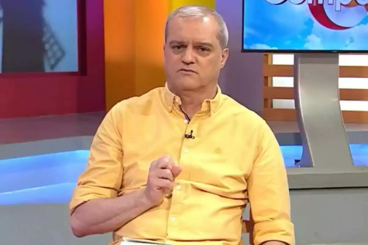 Ramón García con cabello canoso y camisa amarilla sentado en 'En Compañía' con expresión seria